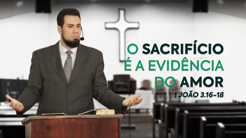 Imagem cujo fundo está desfocado, e é uma foto da parede de trás da nave da igreja, com uma cruz e, mais à frente, bancos aos lados. Em destaque, do lado esquerdo, está o Rev. Thiago Mattos atrás do púlpito. E ao lado direito, o título e a passagem bíblica do sermão em verde: "O sacrifício é a evidência do amor - 1 João 3.16-18".